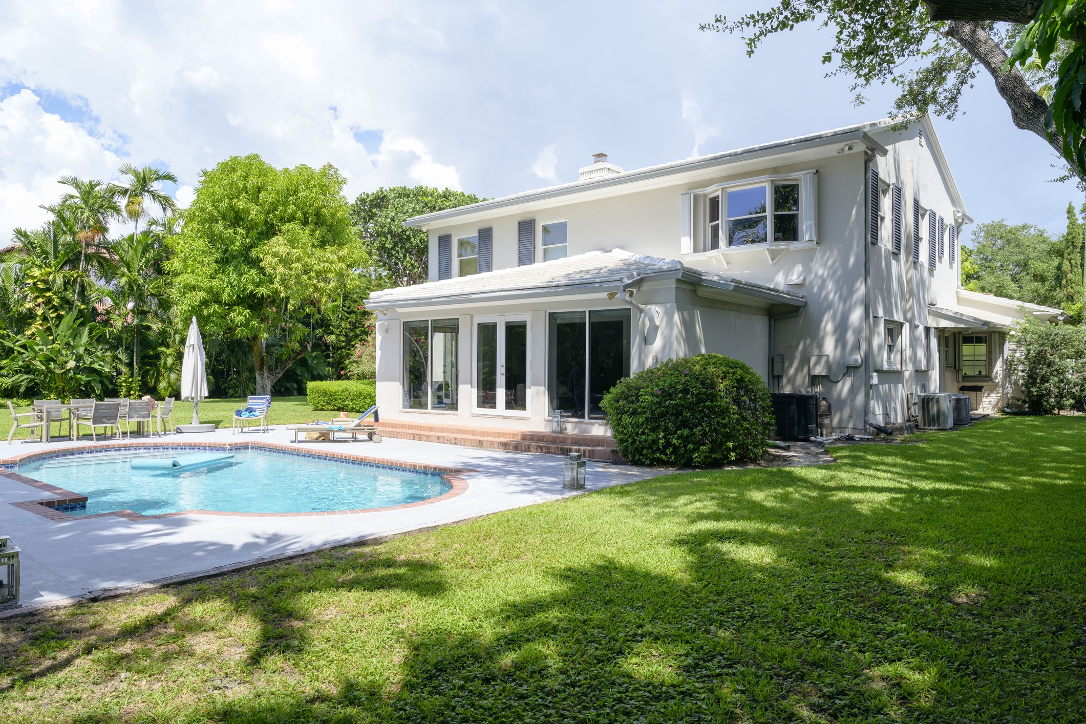 Backyard view of a modern two-story single family detached home with yard and swimming pool