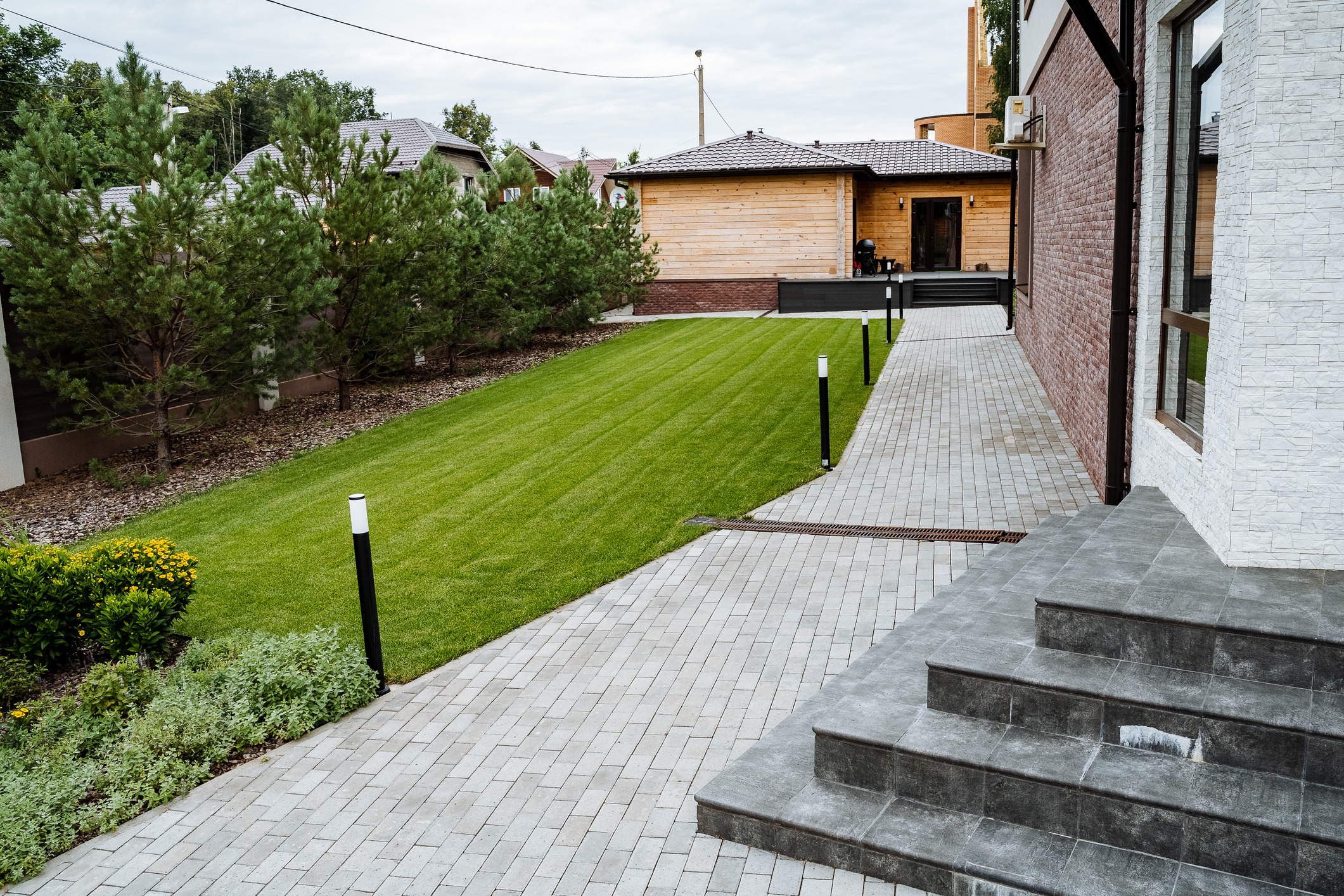 This stunning backyard features a manicured lawn, delightful walkway, and exquisite landscaping, perfect for relaxing and memorable gatherings with family and friends